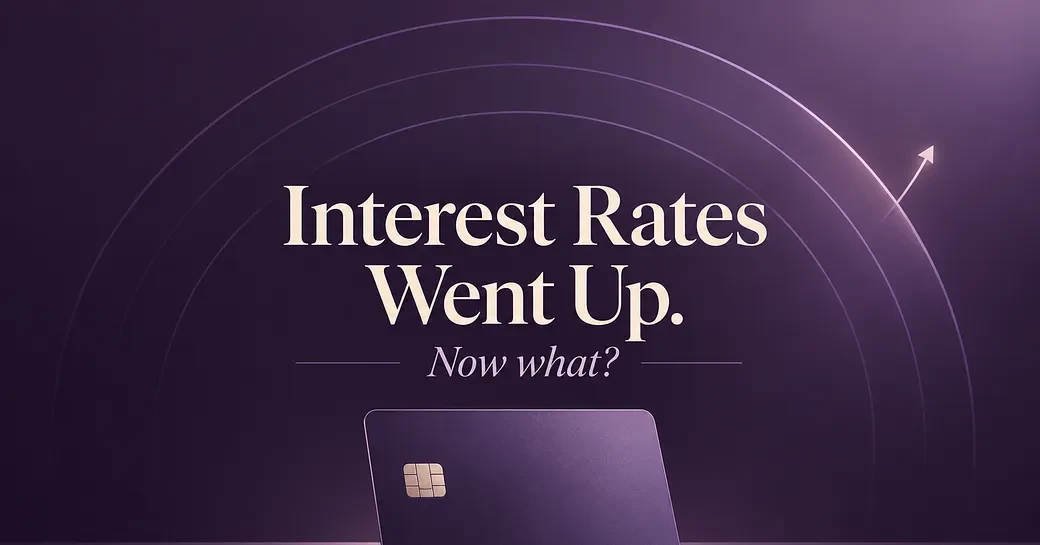 Purple gradient background with concentric circles, upward arrow, credit card, and text reading "Interest Rates Went Up. Now what?"